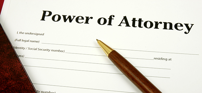 Power Of Attorney form with pen and lawbook.